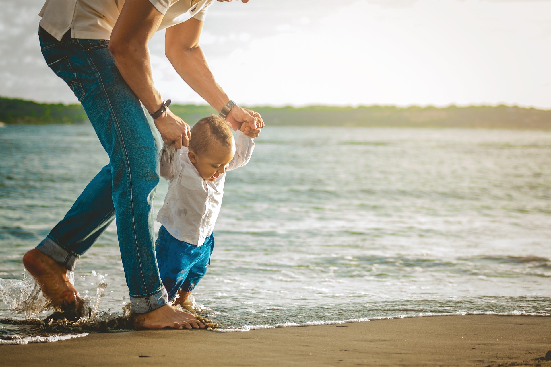 Un parent et son enfant main dans la main au bord de l'eau